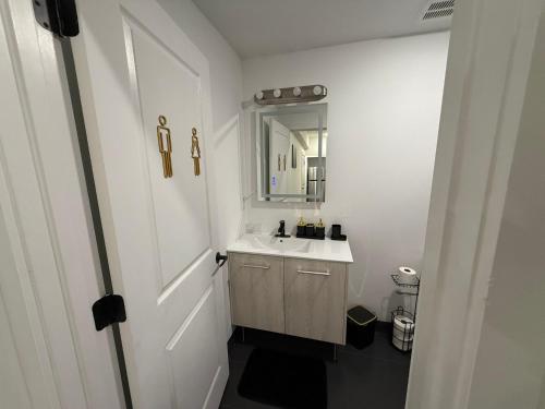 a white bathroom with a sink and a mirror at Cómodo departamento en Elizabeth cerca de NYC in Elizabeth