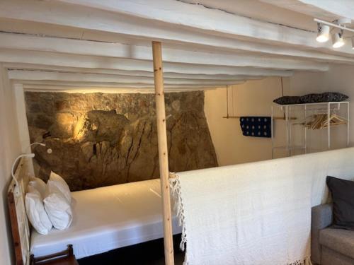a bed in a room with a stone wall at Mona in Poros