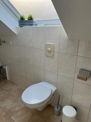a bathroom with a toilet with plants on the wall at Ferienwohnung Madeleine in Haiger