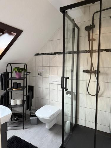 ein Badezimmer mit Toilette und Glasdusche in der Unterkunft Ferienwohnung für Gruppen oder Familien in Schönwies