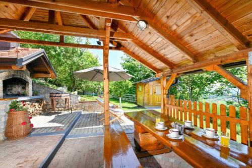 a wooden patio with a table and an umbrella at Holiday home Pavic with jacuzzi and sauna in Krapina
