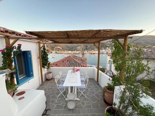 a patio with a table and chairs on a balcony at Mona in Poros