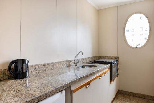 a kitchen with a sink and a microwave at Regent Park Suite Hotel in Sao Paulo