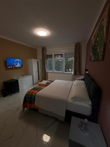 a bedroom with a bed and a couch and a tv at Luna Guest House in Pisa