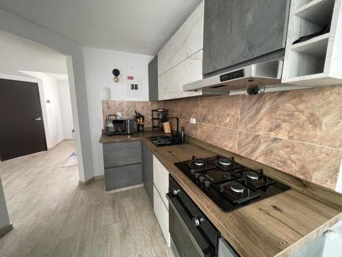 a kitchen with a stove and a counter top at Magnífica y Acogedora Casa en Condomiminio in Jamundí