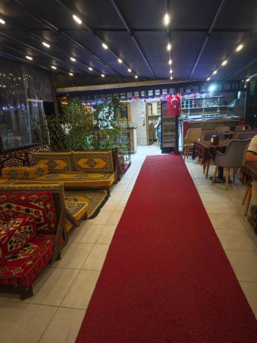 a red carpet in a restaurant with tables and chairs at 61 Dilek Pansiyon in Uzungöl
