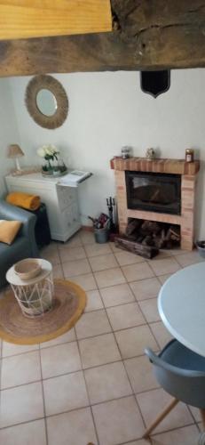 a living room with a table and a fireplace at GÎTE NOTRE-DAME 3p in Matignon