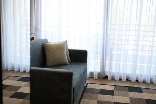 a couch with a pillow in front of a window at Tower Luxury Flats in Alexandroupoli