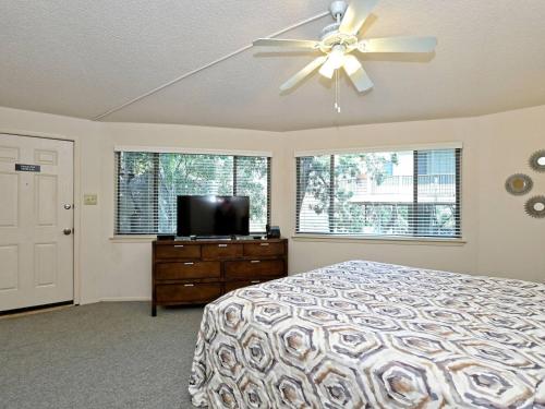 a bedroom with a bed and a ceiling fan at Lakefront Bungalow With Community Poolhot Tub #9 in Lakeway