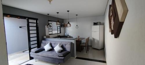a living room with a couch and a kitchen at Casa aconchegante privativa in Limeira