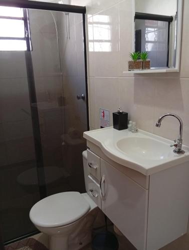 a bathroom with a toilet and a sink and a shower at Casa aconchegante privativa in Limeira
