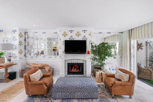 a living room with a fireplace and a tv at Modern Coastal Townhouse at The Majestic in Kalk Bay