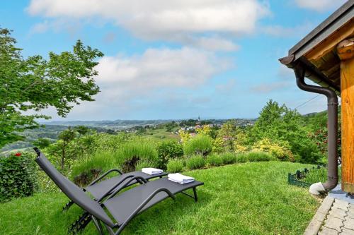 a bench in the grass next to a house at Holiday home Pavic with jacuzzi and sauna in Krapina