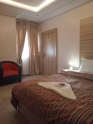 a hotel room with a bed with a surfboard on it at Eagle Nest Apartment and Hotel in Benin City