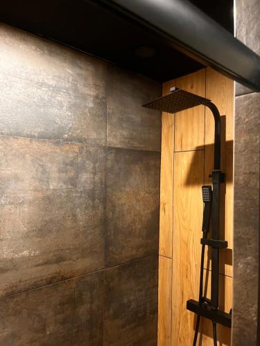 a kitchen with a wooden wall and a black stove at Au cœur des Vosges in Thiéfosse