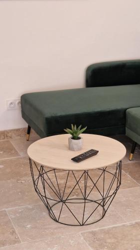 a coffee table in front of a couch with a remote control at Appartement 2 chambres climatisé in Saint-Ambroix