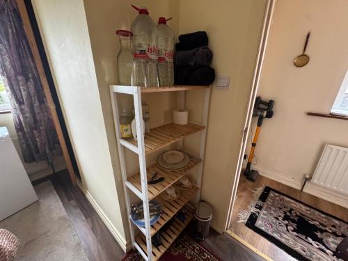 a shelf in a room with bottles on it at Rusty Cottage with View in Blacklion