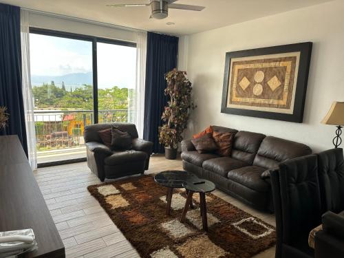 a living room with a leather couch and a table at Luxor and Condo Hotel in Ajijic
