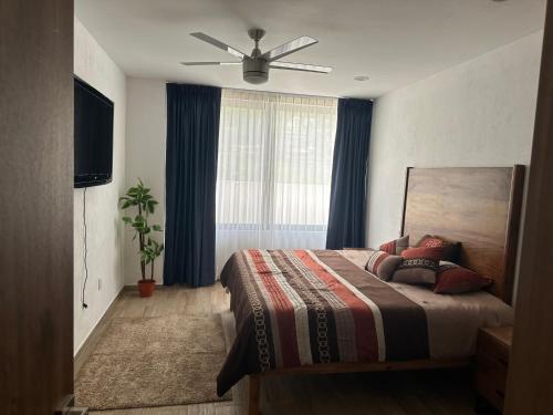 a bedroom with a bed and a ceiling fan at Luxor and Condo Hotel in Ajijic