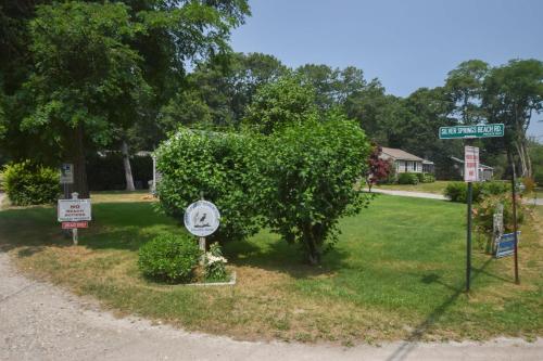 a bush with a clock and signs on a street at Short Walk to Private Association Beach in Eastham