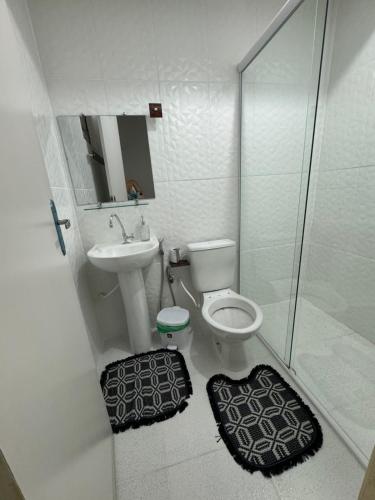 a bathroom with a toilet and a sink and a shower at Suite aconchego Belém in Una