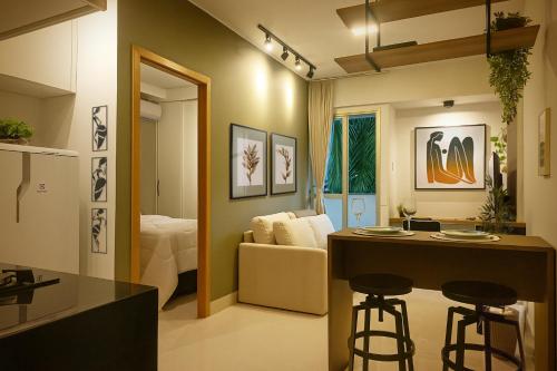 a kitchen and living room with a couch and a table at Apê super charmoso! Ar-condicionado e piscina in Brasilia