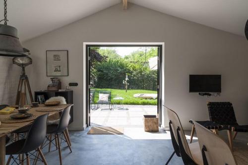 ein Esszimmer mit Tisch und Stühlen und einem Fernseher in der Unterkunft Vakantiehuisjes Theodorus en Josephine - Landgoed Heerdeberg- Maastricht in Cadier en Keer