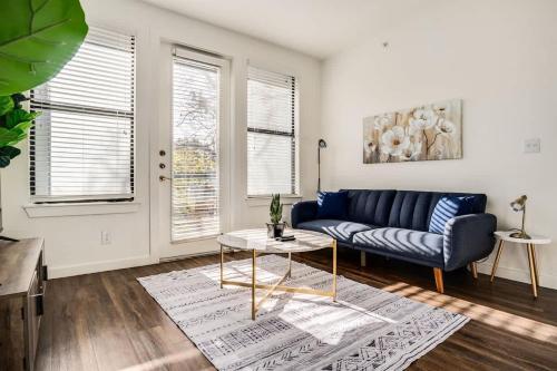 a living room with a blue couch and a table at Boulevard Stays Walk to Downtown 1BR SoCo Pool Parking Gym 06 in Austin