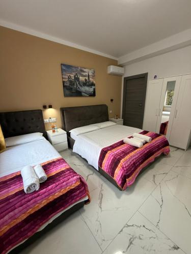 two beds in a room with marble floors at Desire guest House in Pisa