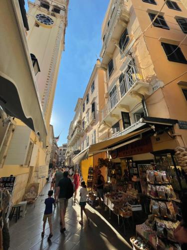 a group of people walking down a street with buildings at Campanile in Corfu