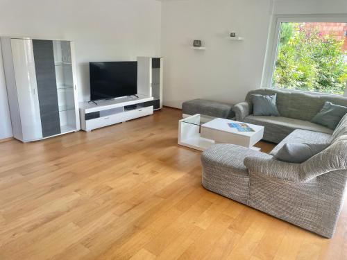 een woonkamer met een bank en een televisie bij REHBLICK Ferienwohnung in Trösel