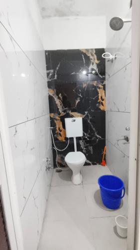 a bathroom with a toilet and a black wall at Kavya Home stay in Ujjain