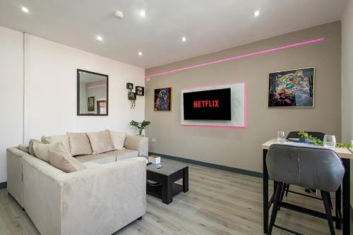 a living room with a white couch and a table at Home Near Leeds City Centre & Elland Road in Beeston