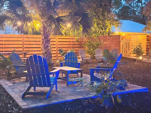 a patio with blue chairs and a table and a fence at Villa Mulvey #2 in Saint Augustine