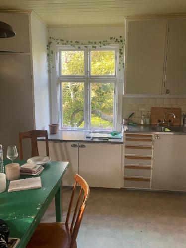 a kitchen with a table and a window at Large house in rosenfors near Borgholm for rent in Borgholm