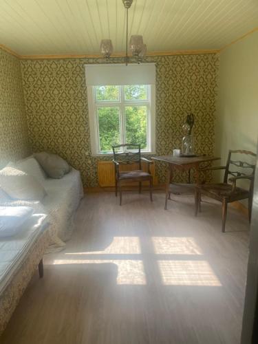 a bedroom with a bed and a table and a window at Large house in rosenfors near Borgholm for rent in Borgholm