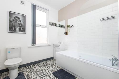 a white bathroom with a tub and a toilet at Home Near Leeds City Centre & Elland Road in Beeston