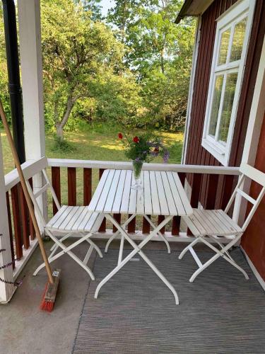 a white bench on a porch with a vase of flowers at Large house in rosenfors near Borgholm for rent in Borgholm
