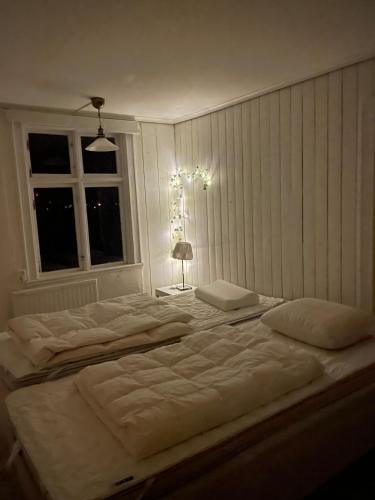 a large white bed in a room with a window at Large house in rosenfors near Borgholm for rent in Borgholm