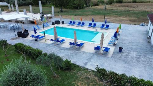 an overhead view of a swimming pool with chairs and umbrellas at Le follie in Maddaloni