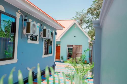 a blue house with a garden in front of it at Avek Home Stay Ngorongoro Room in Uru
