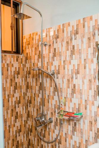 a shower in a bathroom with a tile wall at Avek Home Stay Ngorongoro Room in Uru
