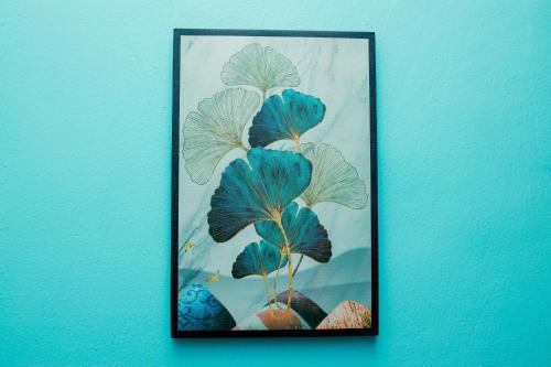 a picture of a plant on a blue wall at Avek Home Stay Ngorongoro Room in Uru