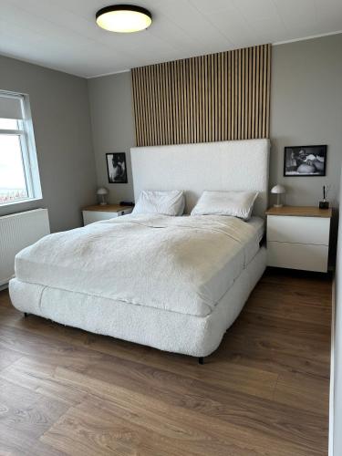 a bedroom with a large white bed and two tables at Great Villa in Ólafsvík in Ólafsvík