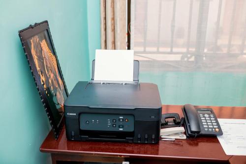 a printer and a phone sitting on a desk at Avek Home Stay Ngorongoro Room in Uru