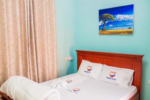 a bedroom with a bed with a blue wall at Avek Home Stay Ngorongoro Room in Uru