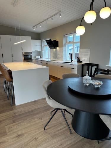 a kitchen and dining room with a black table and chairs at Great Villa in Ólafsvík in Ólafsvík