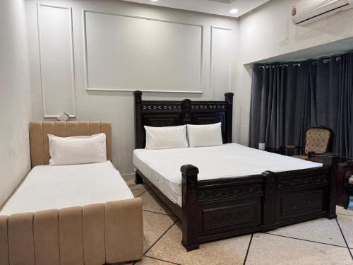 a bedroom with two beds and a couch at Arizona Lodge 2 in Islamabad