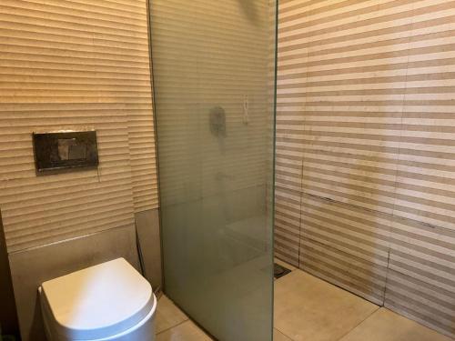 a bathroom with a toilet and a glass shower at Arizona Lodge 2 in Islamabad