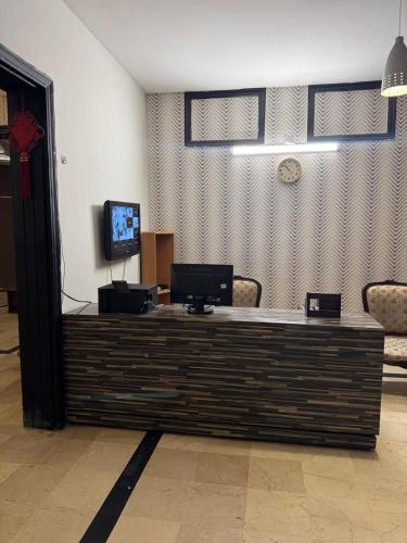 a lobby with a counter with a tv on it at Arizona Lodge 2 in Islamabad
